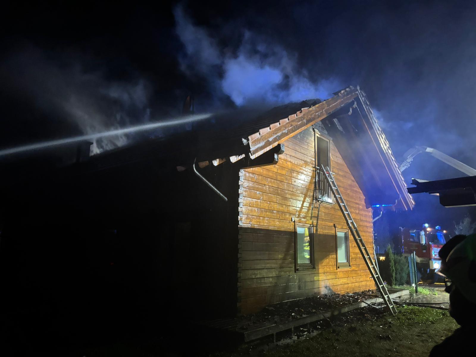 Holzhaus brennt: Feuerwehr löscht mit Wasserwerfer vom Korb, Leiter am Gebäude